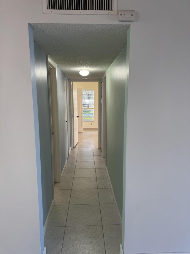 7535 S Orile Blvd Unit 108, Delray Beach, FL 33446 - hall featuring baseboards, light tile patterned floors, and a textured ceiling