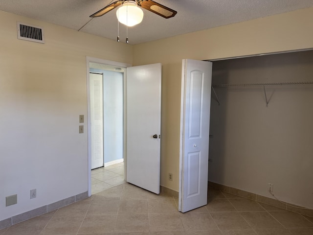 7535 S Orile Blvd Unit 108, Delray Beach, FL 33446 - unfurnished bedroom featuring light tile patterned floors, a closet, baseboards, ceiling fan, and a textured ceiling