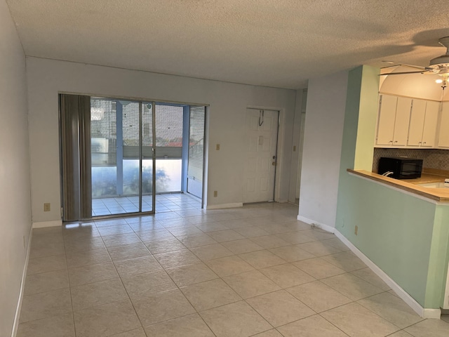 7535 S Orile Blvd Unit 108, Delray Beach, FL 33446 - unfurnished room with a ceiling fan, a textured ceiling, light tile patterned floors, and baseboards
