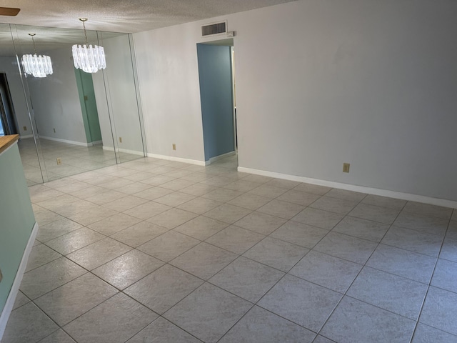 7535 S Orile Blvd Unit 108, Delray Beach, FL 33446 - unfurnished room with a textured ceiling, a chandelier, tile patterned flooring, and baseboards