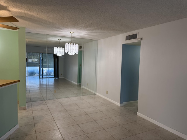 7535 S Orile Blvd Unit 108, Delray Beach, FL 33446 - unfurnished room with a chandelier, tile patterned floors, a ceiling fan, a textured ceiling, and baseboards