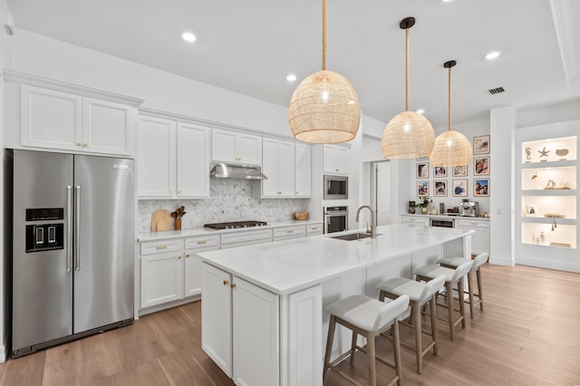 10803 Stellar Cir, Palm Beach Gardens, FL 33412 - kitchen with stainless steel appliances, under cabinet range hood, white cabinetry, and recessed lighting