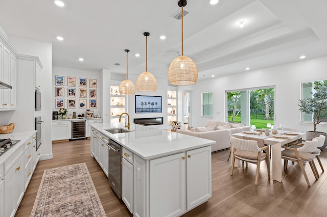 10803 Stellar Cir, Palm Beach Gardens, FL 33412 - kitchen featuring a sink, wine cooler, recessed lighting, stainless steel appliances, and white cabinetry