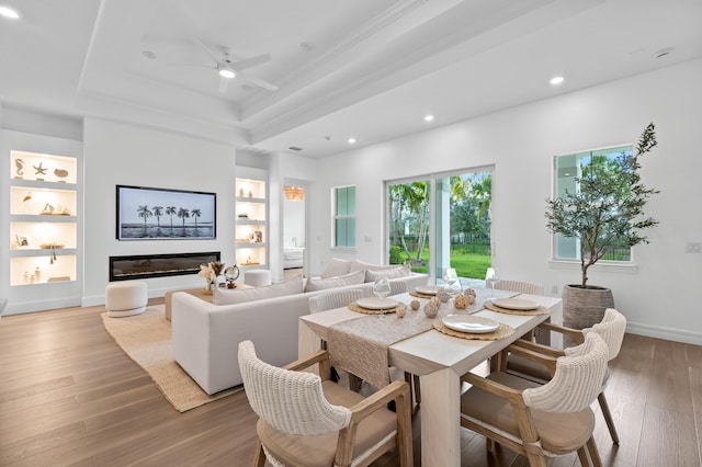 10803 Stellar Cir, Palm Beach Gardens, FL 33412 - living room featuring light wood-style floors, built in features, a tray ceiling, ceiling fan, and recessed lighting