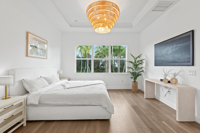10803 Stellar Cir, Palm Beach Gardens, FL 33412 - bedroom featuring a tray ceiling, wood finished floors, ornamental molding, a chandelier, and baseboards