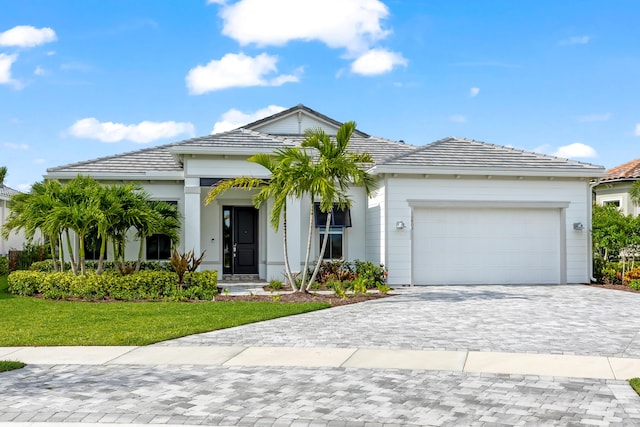 10803 Stellar Cir, Palm Beach Gardens, FL 33412 - view of front facade with an attached garage, decorative driveway, a front yard, and a tile roof