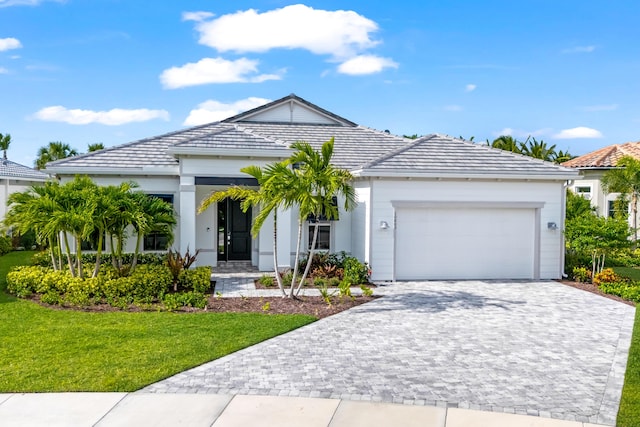 10803 Stellar Cir, Palm Beach Gardens, FL 33412 - ranch-style house with a garage, a front lawn, a tiled roof, and decorative driveway