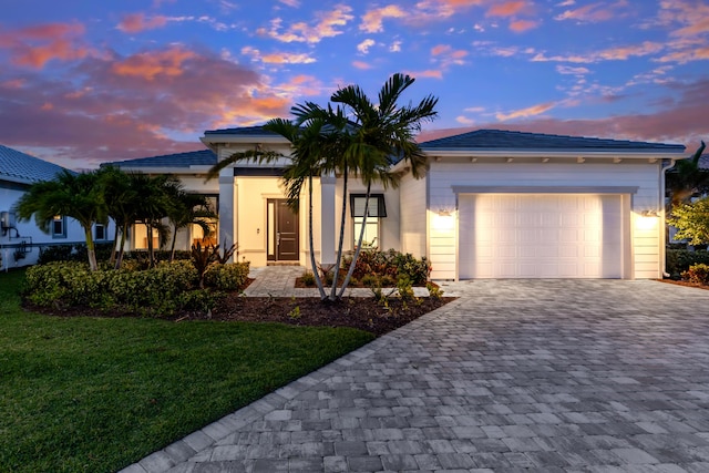 10803 Stellar Cir, Palm Beach Gardens, FL 33412 - view of front facade featuring decorative driveway, a garage, and a yard
