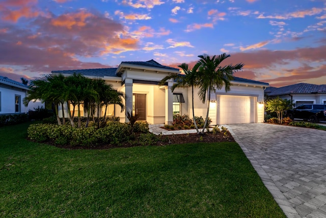 10803 Stellar Cir, Palm Beach Gardens, FL 33412 - view of front of home with an attached garage, decorative driveway, a lawn, and stucco siding