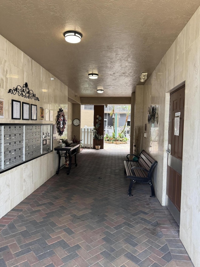 7715 Southampton Ter Unit 102, Tamarac, FL 33321 - hall with mail area and a textured ceiling
