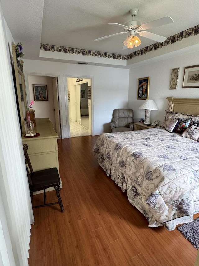 7715 Southampton Ter Unit 102, Tamarac, FL 33321 - bedroom with wood finished floors, a raised ceiling, and ceiling fan