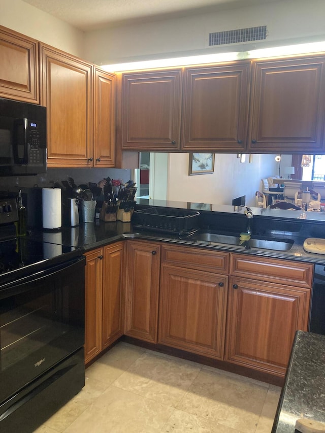 1401 Tidal Pointe Blvd Unit 102, Jupiter, FL 33477 - kitchen with black appliances, a sink, dark stone counters, and brown cabinetry