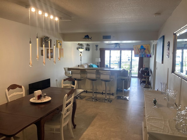 1401 Tidal Pointe Blvd Unit 102, Jupiter, FL 33477 - dining room with a textured ceiling, a bar, and ceiling fan
