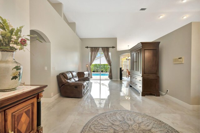 4610 Bucida Rd, Boynton Beach, FL 33436 - living room with arched walkways, light marble finish flooring, baseboards, and high vaulted ceiling