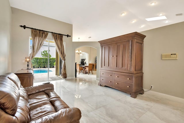 4610 Bucida Rd, Boynton Beach, FL 33436 - living area with light marble finish floors, arched walkways, a chandelier, and baseboards