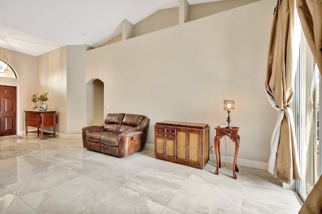 4610 Bucida Rd, Boynton Beach, FL 33436 - living area with light marble finish flooring, high vaulted ceiling, arched walkways, and baseboards