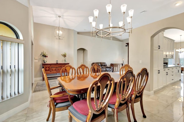 4610 Bucida Rd, Boynton Beach, FL 33436 - dining area featuring arched walkways, a chandelier, baseboards, and light marble finish flooring