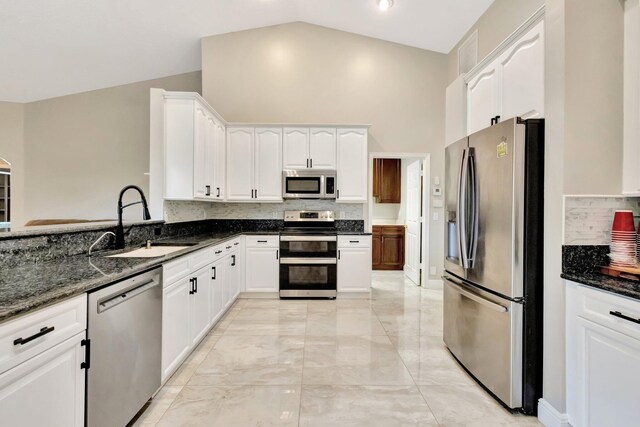4610 Bucida Rd, Boynton Beach, FL 33436 - kitchen with stainless steel appliances, a sink, high vaulted ceiling, dark stone countertops, and decorative backsplash