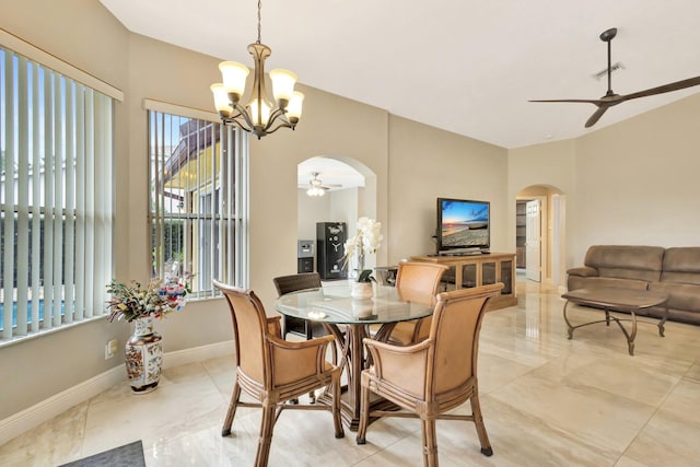 4610 Bucida Rd, Boynton Beach, FL 33436 - dining space featuring arched walkways, a ceiling fan, a chandelier, light marble finish floors, and baseboards