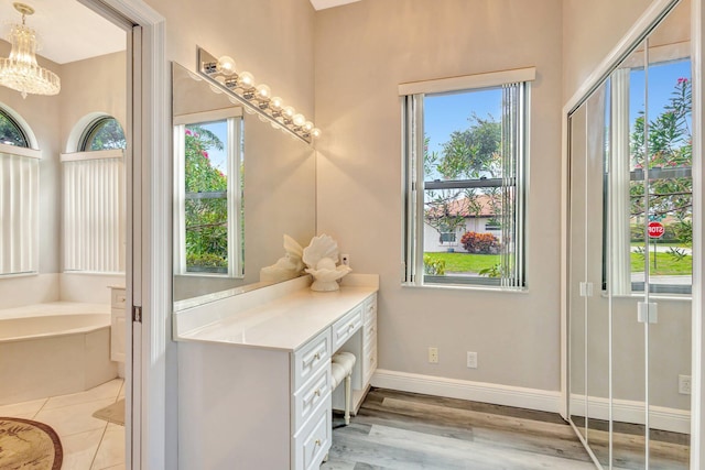 4610 Bucida Rd, Boynton Beach, FL 33436 - bathroom featuring a bath, a chandelier, baseboards, and wood finished floors