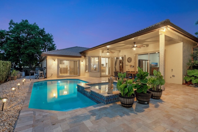 4610 Bucida Rd, Boynton Beach, FL 33436 - back of house at dusk with stucco siding, ceiling fan, and a patio