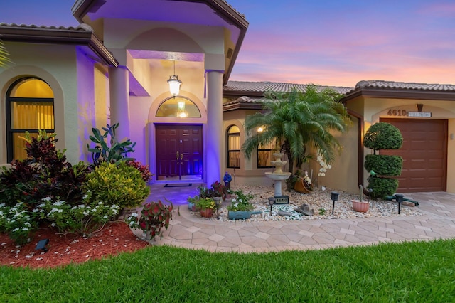 4610 Bucida Rd, Boynton Beach, FL 33436 - entrance to property featuring stucco siding, a garage, and a tiled roof
