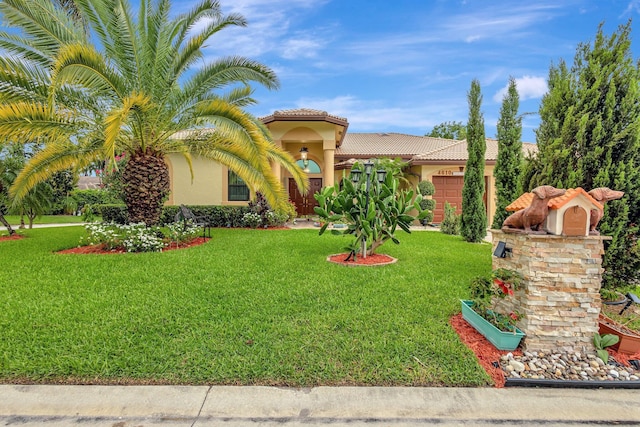 4610 Bucida Rd, Boynton Beach, FL 33436 - mediterranean / spanish house with stucco siding, a tiled roof, an attached garage, and a front lawn