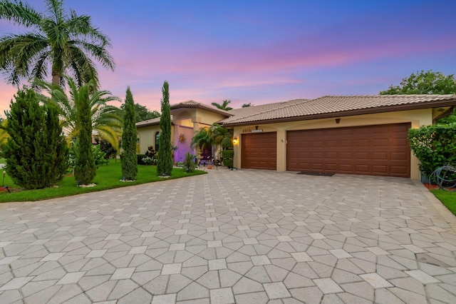 4610 Bucida Rd, Boynton Beach, FL 33436 - mediterranean / spanish home featuring decorative driveway, stucco siding, a tiled roof, a garage, and a front lawn