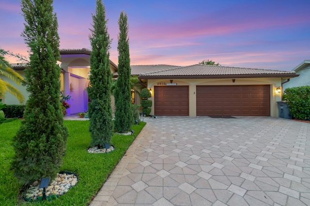 4610 Bucida Rd, Boynton Beach, FL 33436 - view of front of home with a tile roof, decorative driveway, stucco siding, and an attached garage