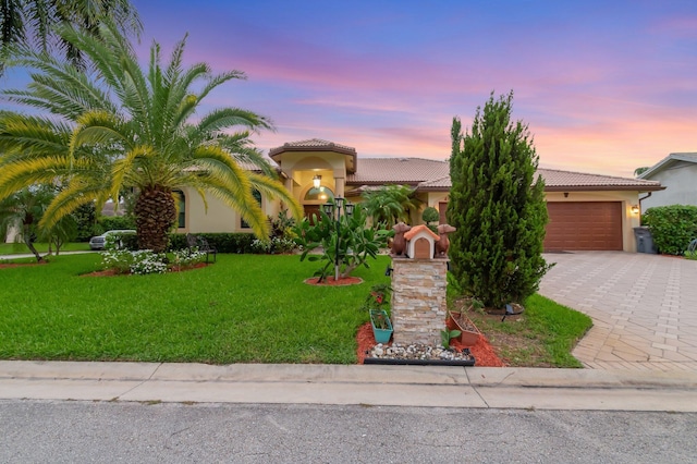 4610 Bucida Rd, Boynton Beach, FL 33436 - view of front facade featuring a tiled roof, an attached garage, stucco siding, driveway, and a yard