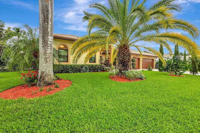 4610 Bucida Rd, Boynton Beach, FL 33436 - view of front facade featuring an attached garage, a front lawn, stucco siding, and a tiled roof