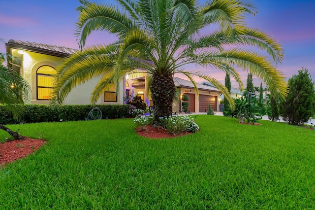 4610 Bucida Rd, Boynton Beach, FL 33436 - view of front facade with a yard, an attached garage, and stucco siding