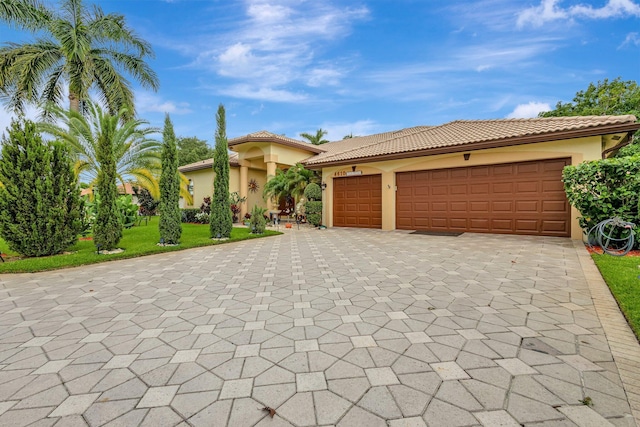 4610 Bucida Rd, Boynton Beach, FL 33436 - mediterranean / spanish-style home featuring stucco siding, decorative driveway, a garage, and a tile roof