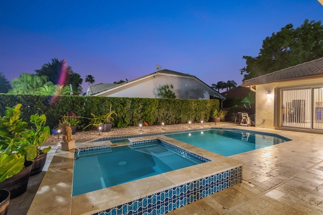 4610 Bucida Rd, Boynton Beach, FL 33436 - pool at dusk with an in-ground hot tub, a fenced backyard, and a patio