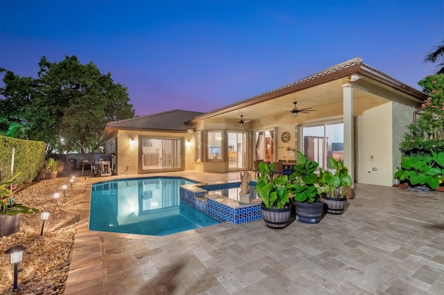 4610 Bucida Rd, Boynton Beach, FL 33436 - pool at dusk featuring a ceiling fan, a patio, and a pool with connected hot tub