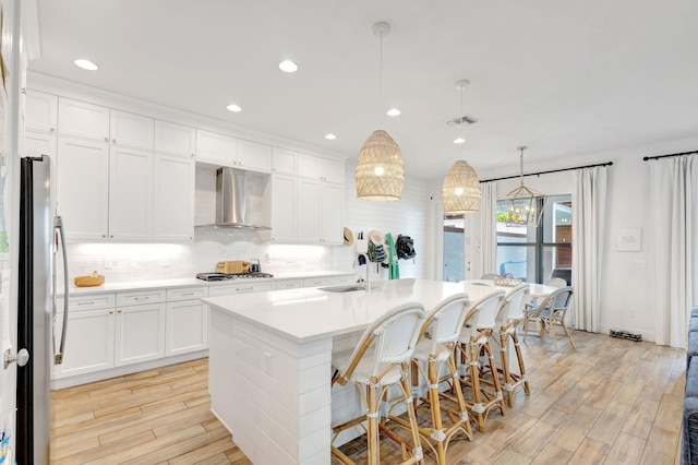 13291 Machiavelli Way, Palm Beach Gardens, FL 33418 - kitchen featuring wall chimney exhaust hood, a sink, stainless steel appliances, light wood-type flooring, and recessed lighting