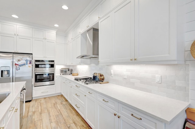 13291 Machiavelli Way, Palm Beach Gardens, FL 33418 - kitchen with wall chimney range hood, stainless steel appliances, light countertops, white cabinetry, and tasteful backsplash