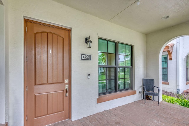 13291 Machiavelli Way, Palm Beach Gardens, FL 33418 - view of exterior entry featuring stucco siding and covered porch