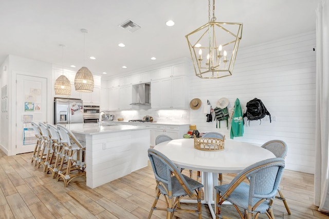 13291 Machiavelli Way, Palm Beach Gardens, FL 33418 - kitchen with wall chimney range hood, a sink, stainless steel fridge with ice dispenser, white cabinets, and light countertops