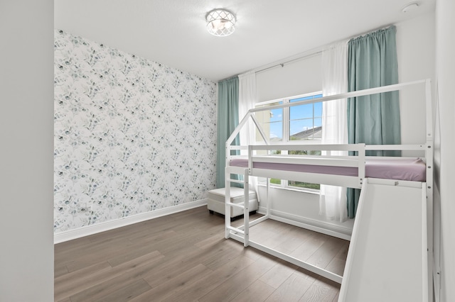 587 Sanderling Cir, Deerfield Beach, FL 33442 - bedroom featuring wallpapered walls, wood finished floors, and baseboards
