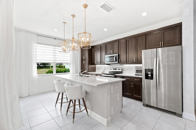 587 Sanderling Cir, Deerfield Beach, FL 33442 - kitchen featuring appliances with stainless steel finishes, a sink, a chandelier, dark brown cabinetry, and light tile patterned floors