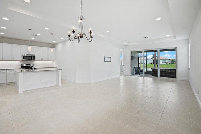 24038 SW Firenze Way, Port Saint Lucie, FL 34986 - kitchen featuring appliances with stainless steel finishes, a raised ceiling, open floor plan, recessed lighting, and baseboards