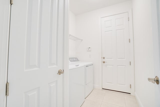 24038 SW Firenze Way, Port Saint Lucie, FL 34986 - washroom featuring washer and clothes dryer, light tile patterned floors, and baseboards