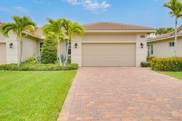 24038 SW Firenze Way, Port Saint Lucie, FL 34986 - view of front facade featuring a front yard, stucco siding, decorative driveway, an attached garage, and a tiled roof