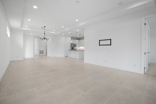 24038 SW Firenze Way, Port Saint Lucie, FL 34986 - unfurnished living room featuring a chandelier, a raised ceiling, recessed lighting, baseboards, and light tile patterned floors