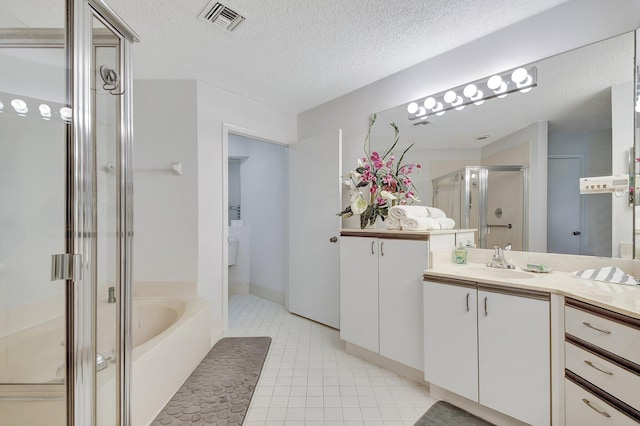 5419 Firenze Dr Unit K, Boynton Beach, FL 33437 - bathroom with vanity, a shower stall, a garden tub, a textured ceiling, and tile patterned floors