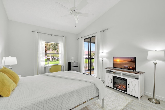 5419 Firenze Dr Unit K, Boynton Beach, FL 33437 - bedroom featuring access to outside, lofted ceiling, light wood-type flooring, baseboards, and a glass covered fireplace