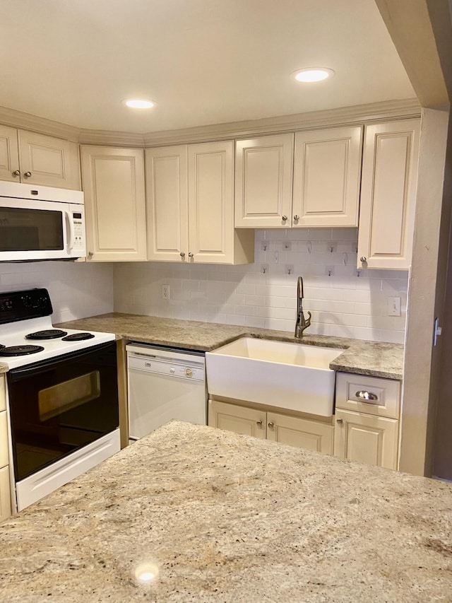 294 Brittany Unit G, Delray Beach, FL 33446 - kitchen with white appliances, tasteful backsplash, light stone counters, and recessed lighting