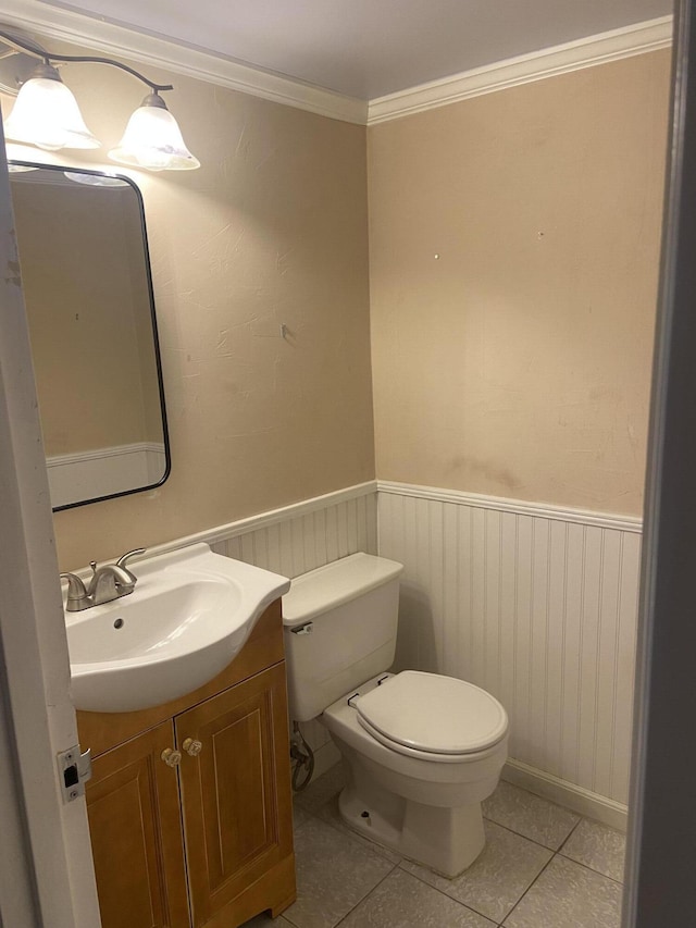 294 Brittany Unit G, Delray Beach, FL 33446 - half bathroom with toilet, vanity, tile patterned flooring, a wainscoted wall, and ornamental molding