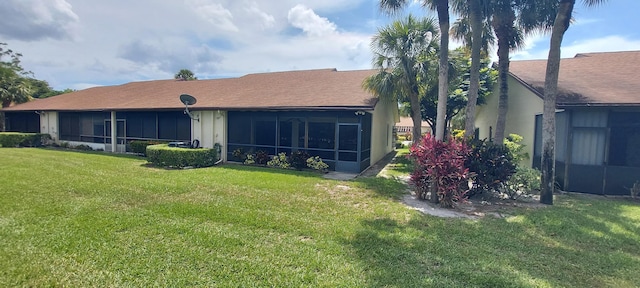 3710 English Rd Unit A, Lake Worth, FL 33467 - back of property with a lawn, a sunroom, and stucco siding